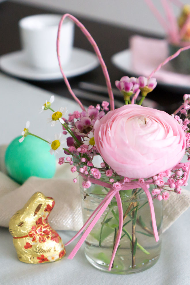 Tischdeko für Ostern: Einweckglas mit Hasenohren und Schnurrbarthaaren auf dem Tisch