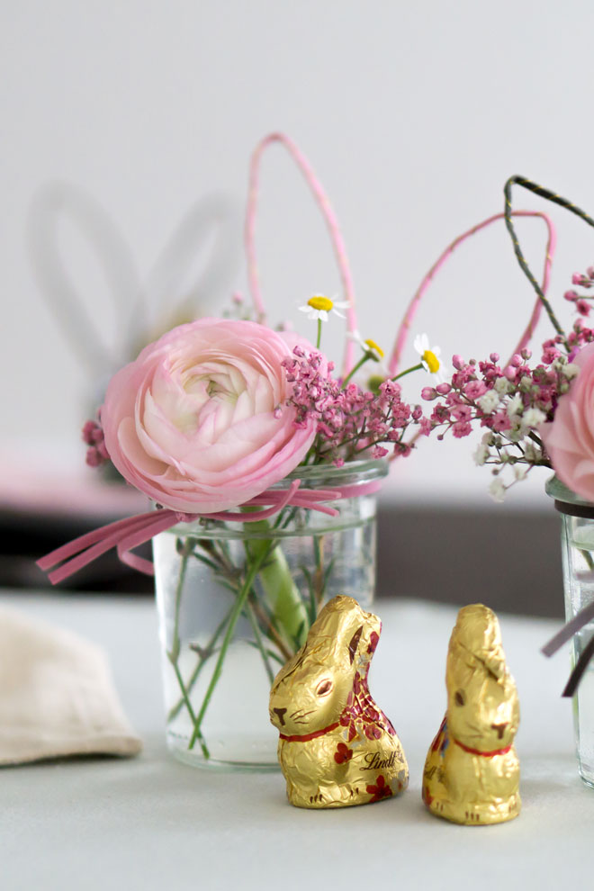 Tischdeko für Ostern: Einweckglas mit Hasenohren und Schnurrbarthaaren als Blumenvase