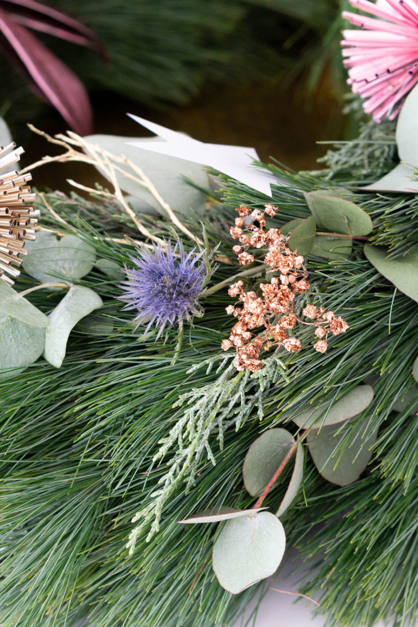 Trockenblumen und Zweige im Metallic-Look im Adventskranz
